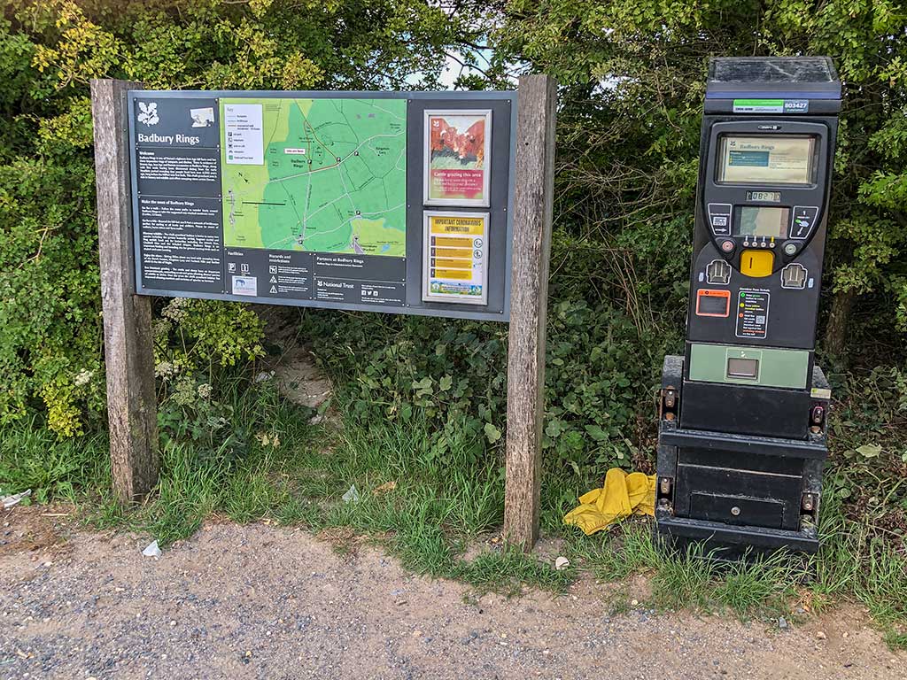 Badbury Rings Car park sign showing a map of the nearby walks and also a brief history of the hill fort