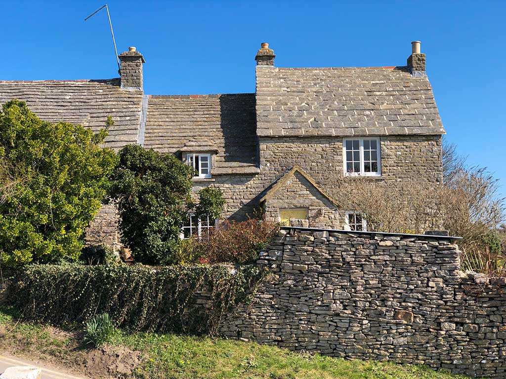 Pretty stone cottages next to the village duck pond in Worth Matravers
